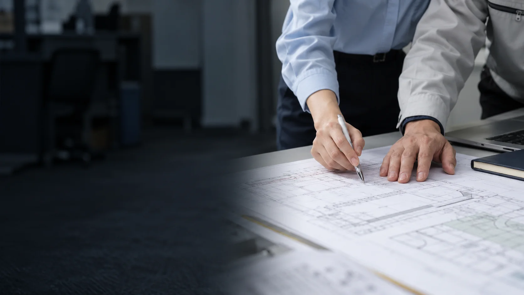 Hands working together over a drawing; a concept photograph